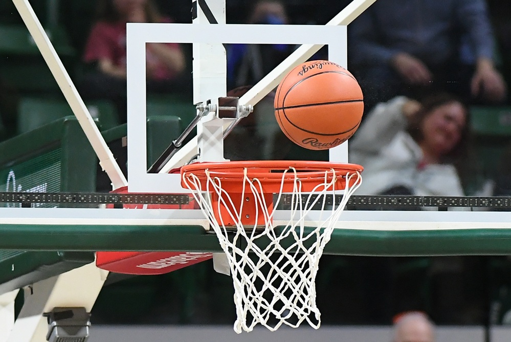 A basketball bounces just above the rim. 