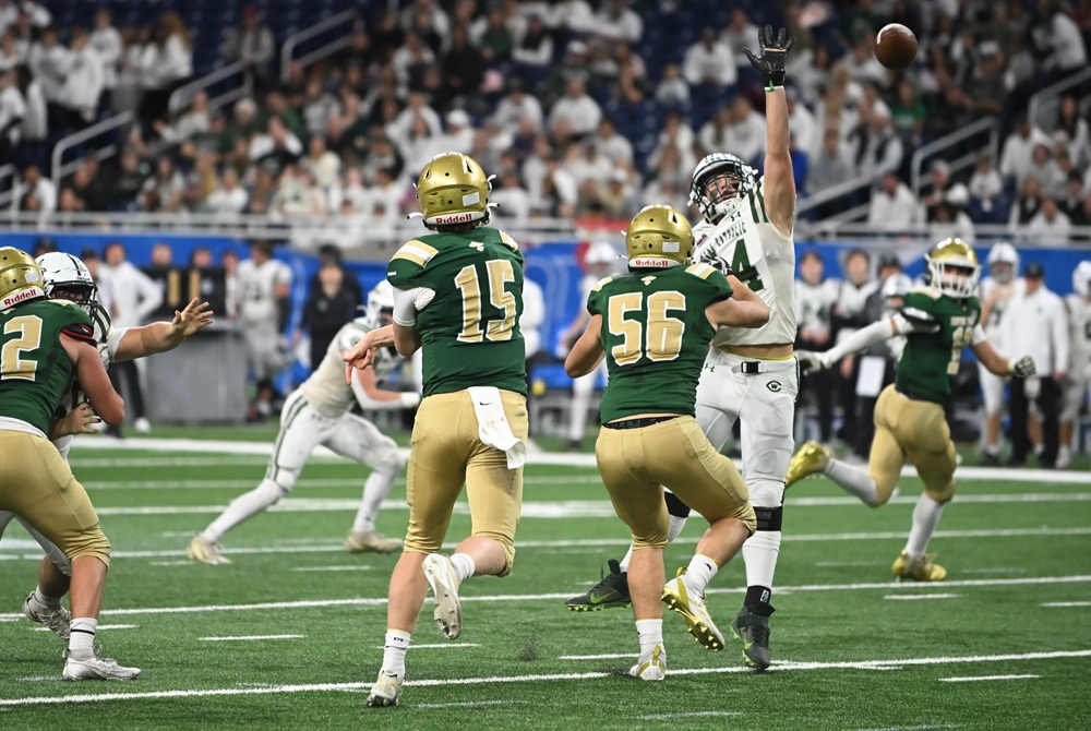 Pontiac Notre Dame Prep quarterback Sam Stowe (15) throws a pass during the Division 5 Final while protected by lineman Adrian Fernandez (56). 