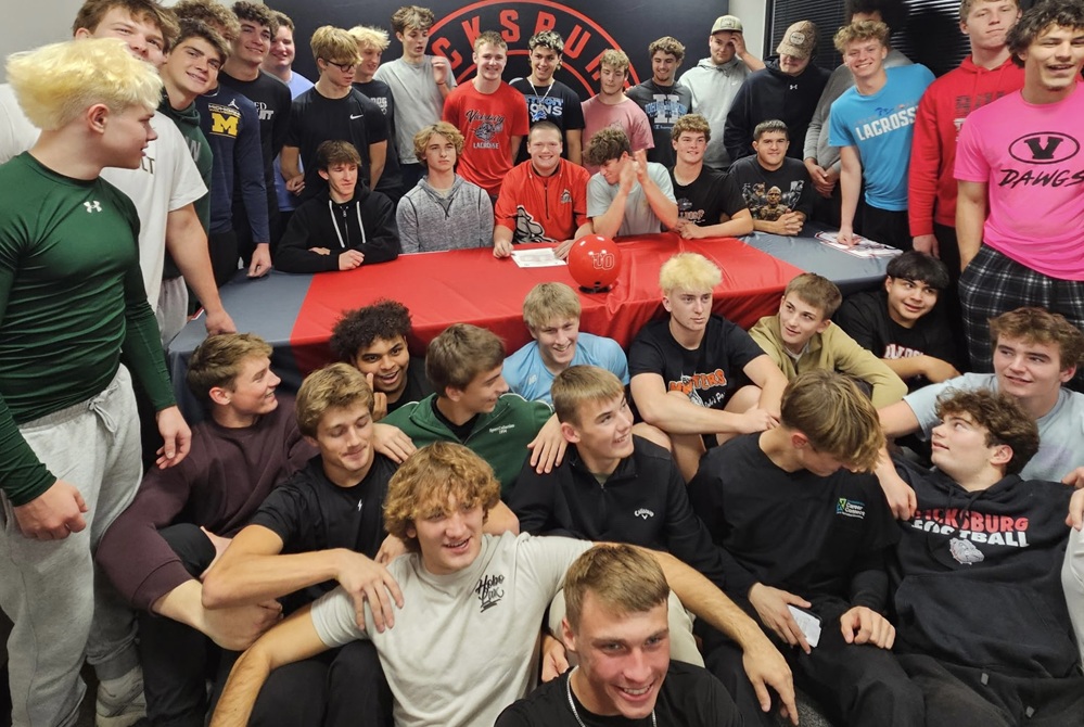 Teammates and friends surround Vicksburg’s Jordon Butler as he signs his commitment to bowl collegiately at University of Olivet.