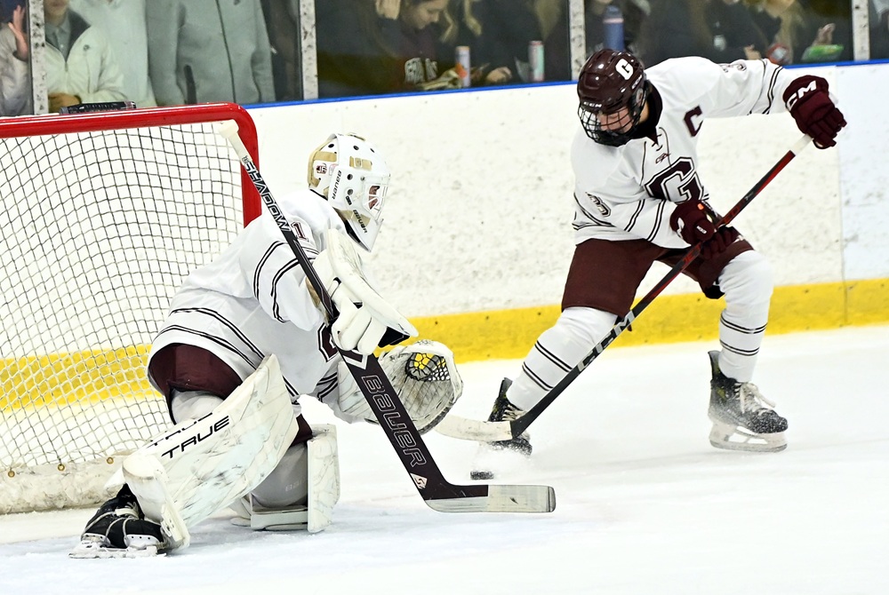 Grandville’s Braden Vander Veen (3) gets his stick on the puck as goalie Ayden Karas walls off that side of the net during a game this season.