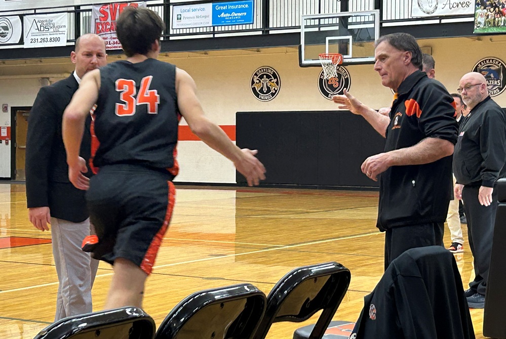 Longtime Cheboygan boys basketball JV coach Scott Hancock sends a starter onto the floor during introductions before a game against Kingsley.