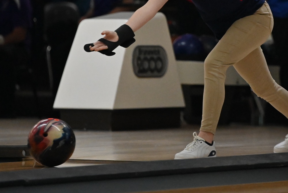 A bowler releases a ball onto the lane.