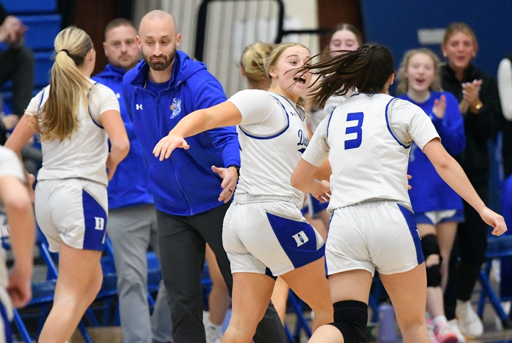 Dundee players are upbeat as they run toward their cheering teammates and coach Jay Briggs during a break in a game this season.