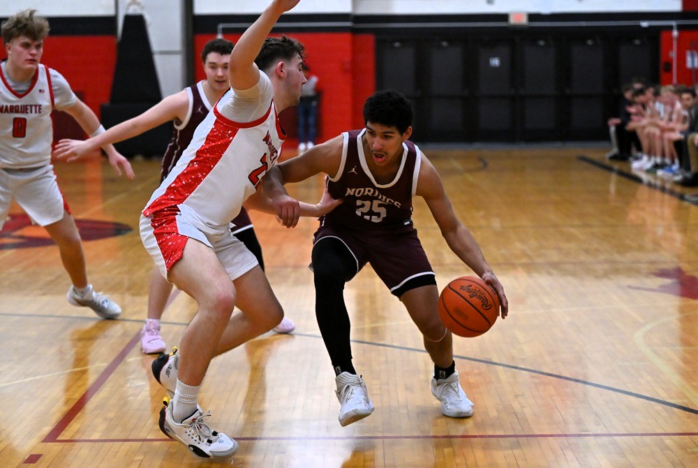 Felch North Dickson's Ty King is guarded closely by Marquette's Connor Fierstine during the Sentinels’ 68-34 victory Friday. 
