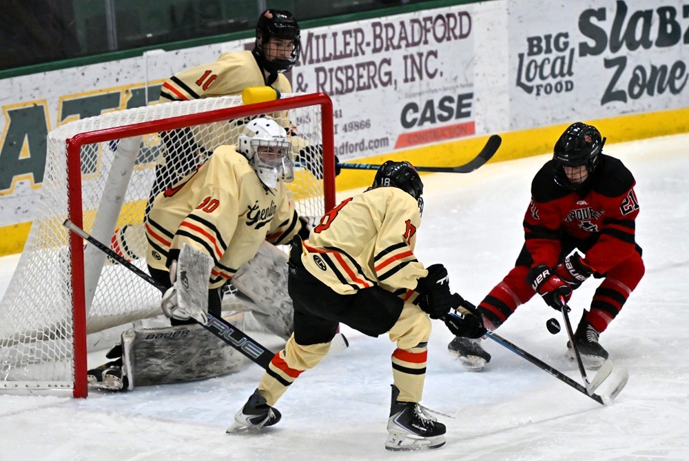 Houghton's Ian Hembroff (18) deflects the puck away from goalie Cooper Flachs and Marquette's Evan Mattila during the Gremlins’ Quarterfinal win Saturday. 