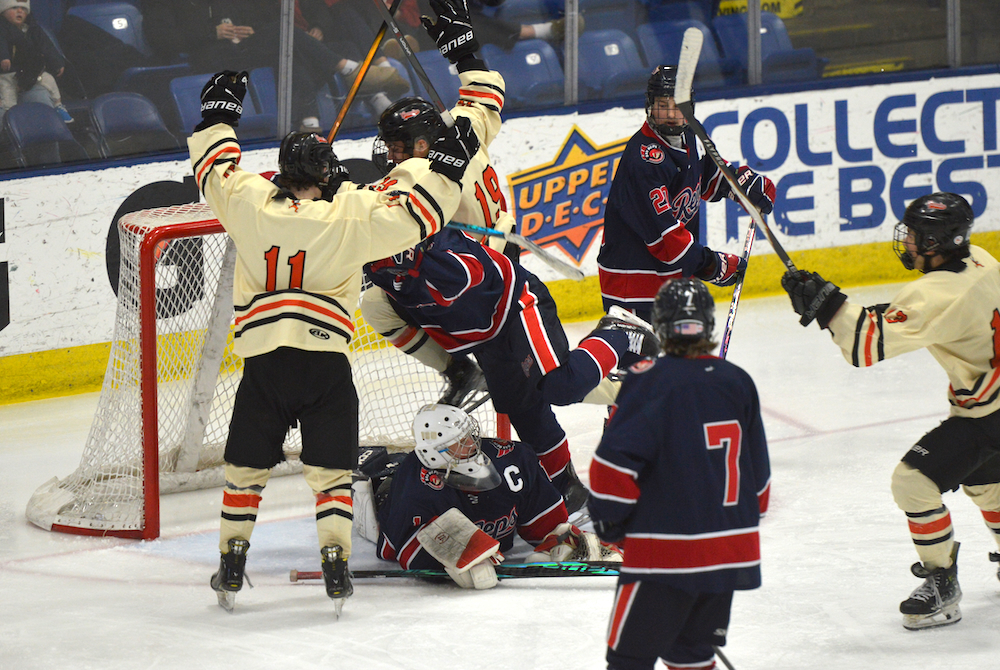 Houghton’s Connor Arko (19) and Jack Sayen (11) celebrate a goal during their Division 3 Semifinal win Friday at USA Hockey Arena. 