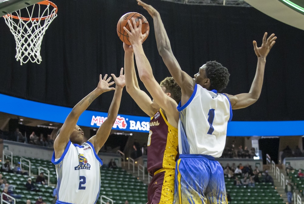 Sherrod Magee (2) and Devonte Grandison (1) defend the basket during the Lions’ Division 3 Semifinal win Thursday at Breslin Center. 