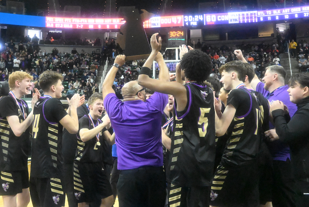 Concord boys basketball coach Marcus Gill Sr. holds up his team’s newly-won championship trophy Saturday at Breslin Center. 