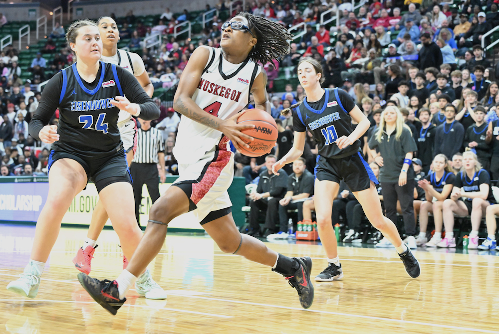 Muskegon's Camiyah Bonner (4) drives to the basket Friday with Eisenhower's Natalya Stojcevski (24) defending. 