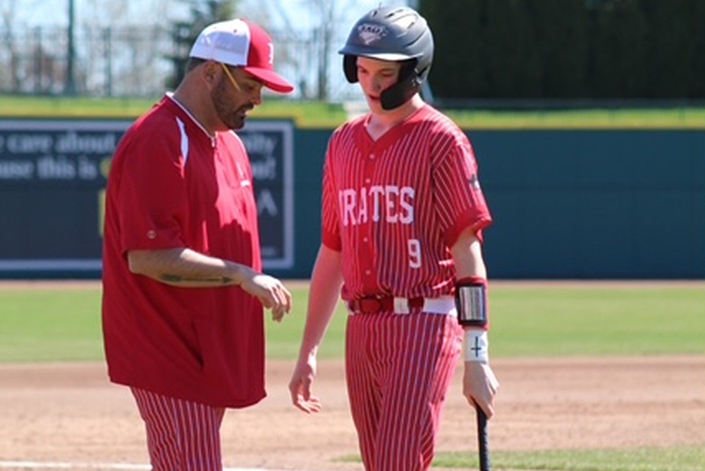 Peck baseball coach James Welch, left, talks with son Grady during a game from a recent season. 
