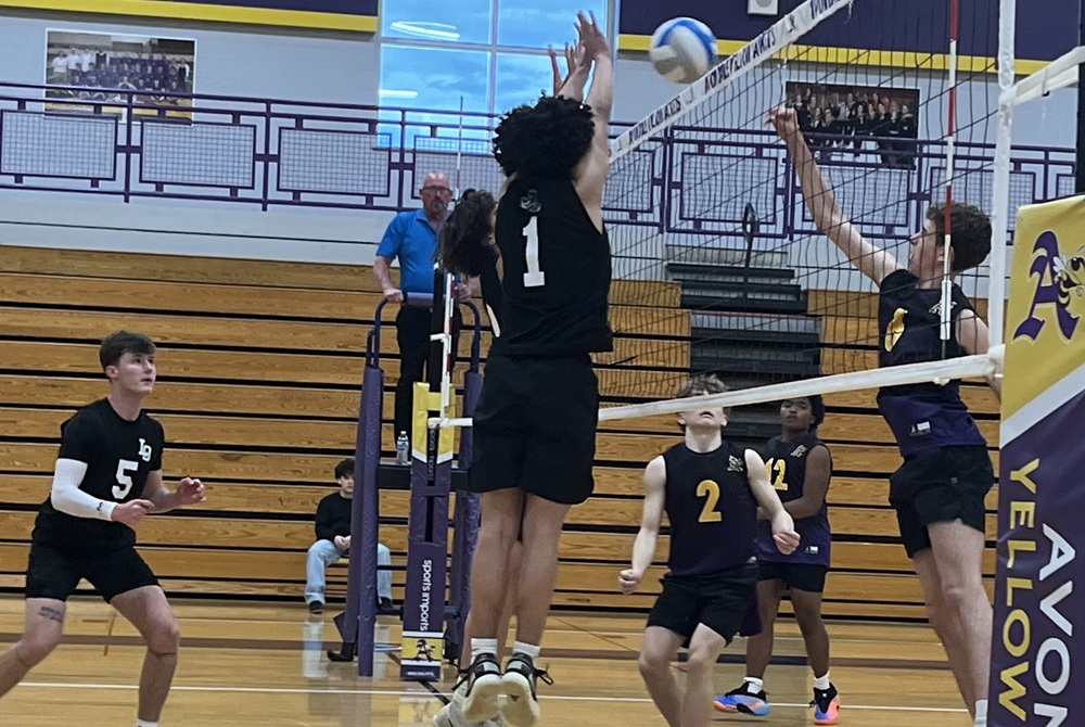 Lake Orion and Auburn Hills Avondale volleyball players battle at the net during a Thursday match. 