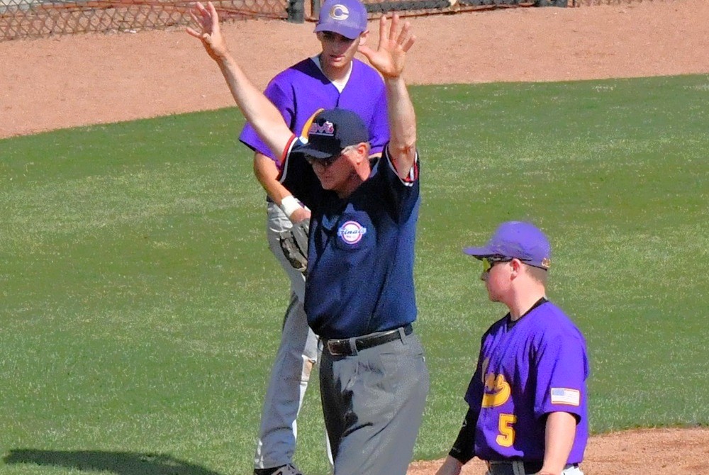 A baseball umpire calls for timeout after a play. 
