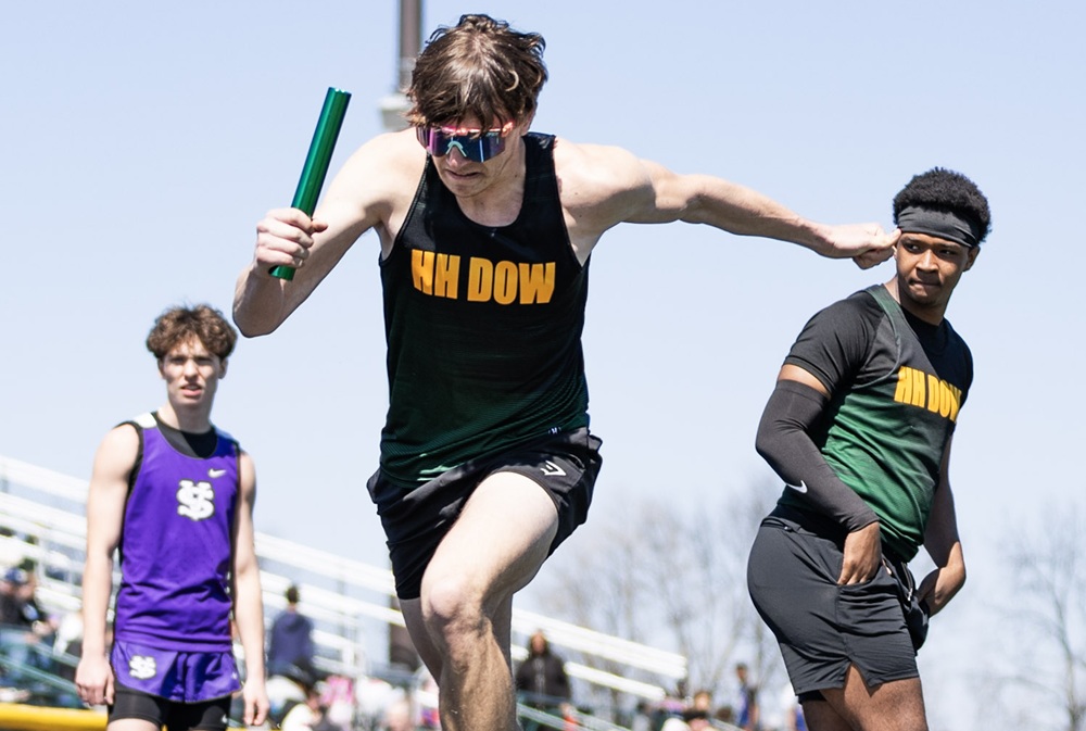 Midland Dow’s Zach Dzurka, with baton, takes off to start a relay race. 