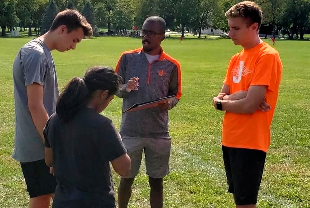 Nathan Martin, middle with clipboard, coaches his Jackson distance runners.
