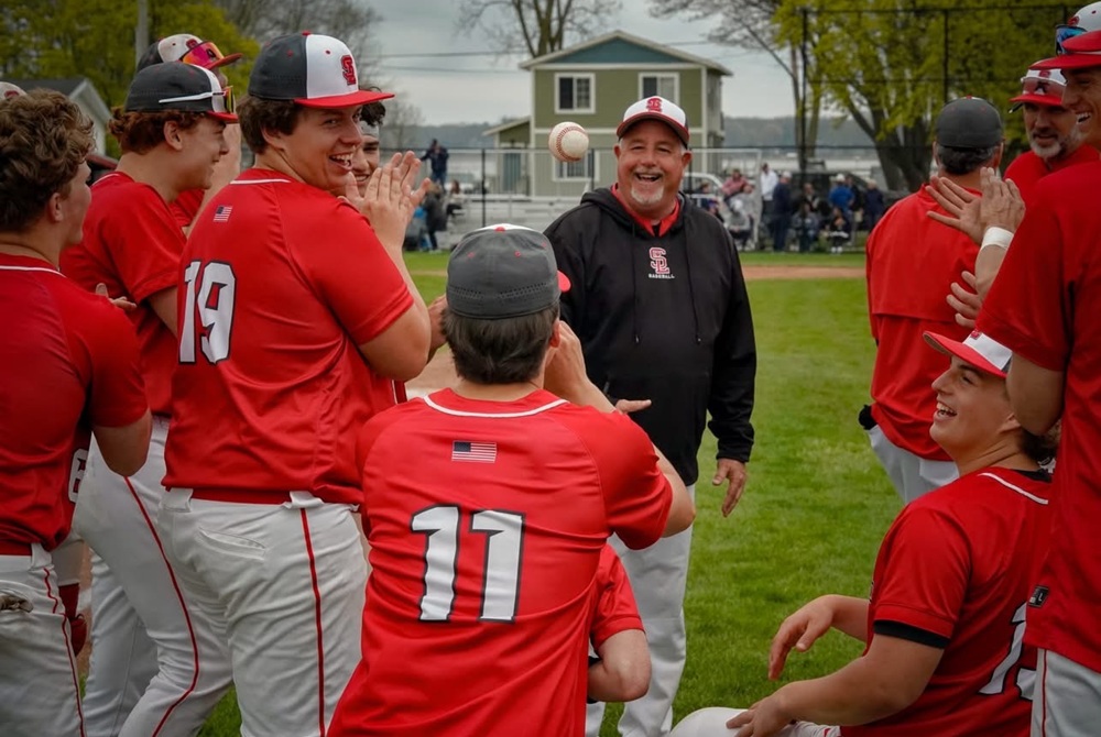 Spring Lake baseball coach Bill Core tosses Maddux Kipling his home run ball after a win over Fruitport.