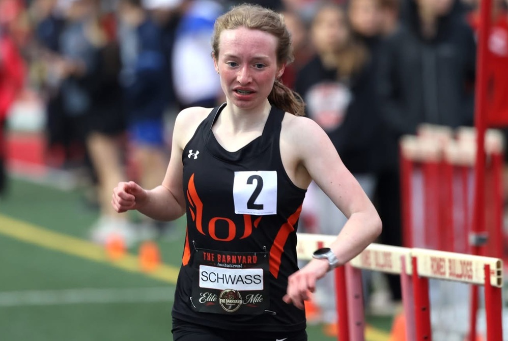 Ludington's Eliza Schwass crosses the finish line in winning the diamond elite 1,600 race at Romeo's Barnyard Invitational.