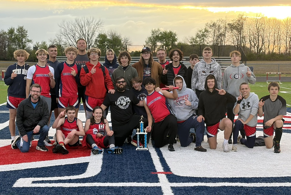 The Britton Deerfield boys track & field team gathers around coach Dustin Longnecker after winning its Bob Beckey Invitational.