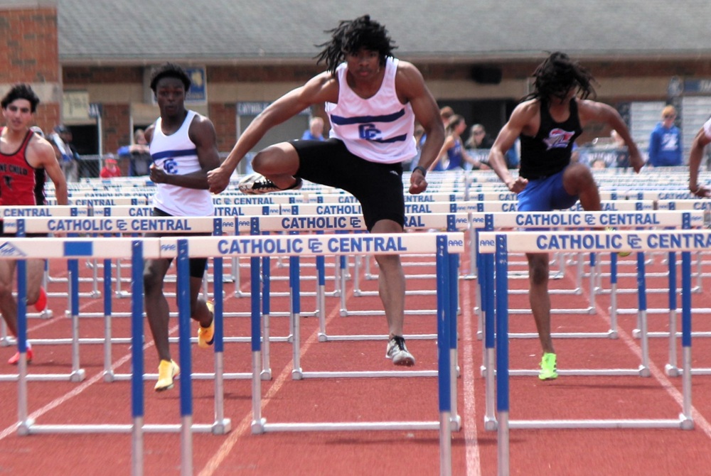 Detroit Catholic Central's Zacchaeus Brocks, middle, clears a hurdle during the CHSL championship meet.