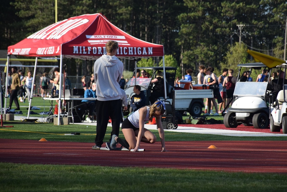 A relay runner sets up in a starting block during the Lower Peninsula Division 1 Regional hosted by Milford on May 15.
