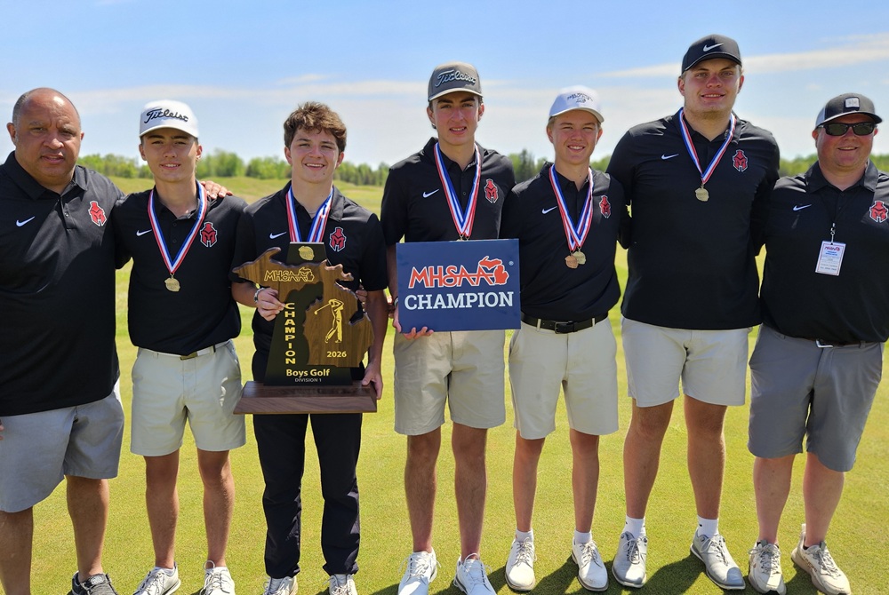 the Marquette boys golf team poses for a photo with its championship trophy.