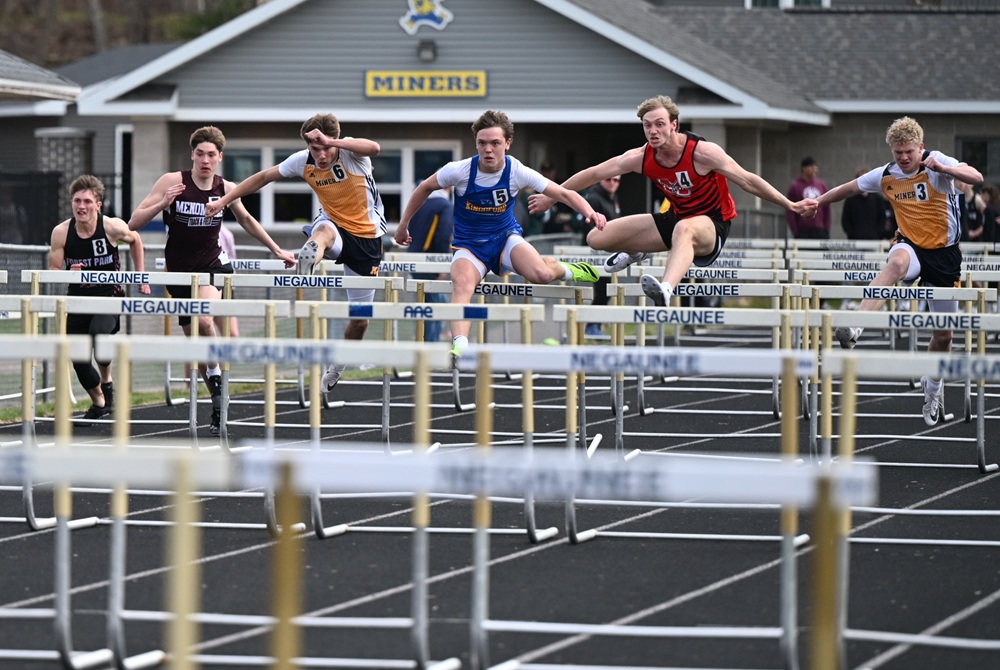 Negaunee's Cole Prusi (6), Kingsford's Sid Olson (5), Marquette's Jacob Norman (4), and Negaunee's Cole Pekrul (3) race the 110 hurdles May 8 at the Lions Invitational in Negaunee.