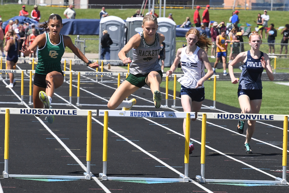 Kalamazoo Hackett Catholic Prep's Clara Slattery, second from left, charges over a hurdle on the way to winning the 100 hurdles championship Saturday.