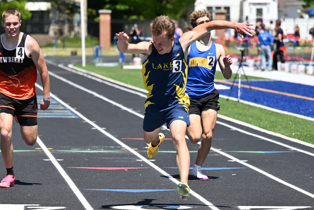 Lake Linden-Hubbell's Lukas Axford, center, crosses the finish line first in the 400 meters Saturday.