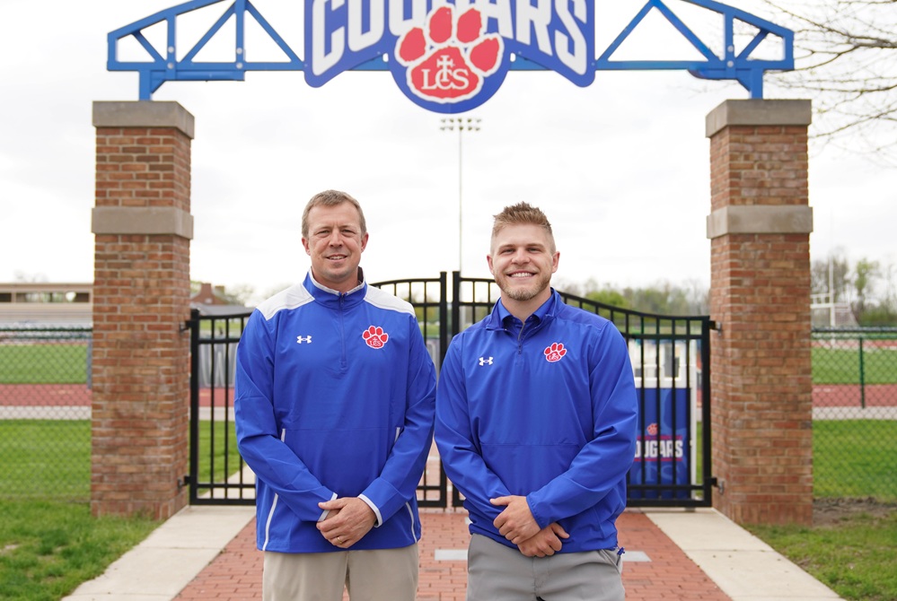 New Adrian Lenawee Christian athletic director Matt Kohn, left, and assistant Noah Beaudrie post for a photo in front of the school’s stadium gate.