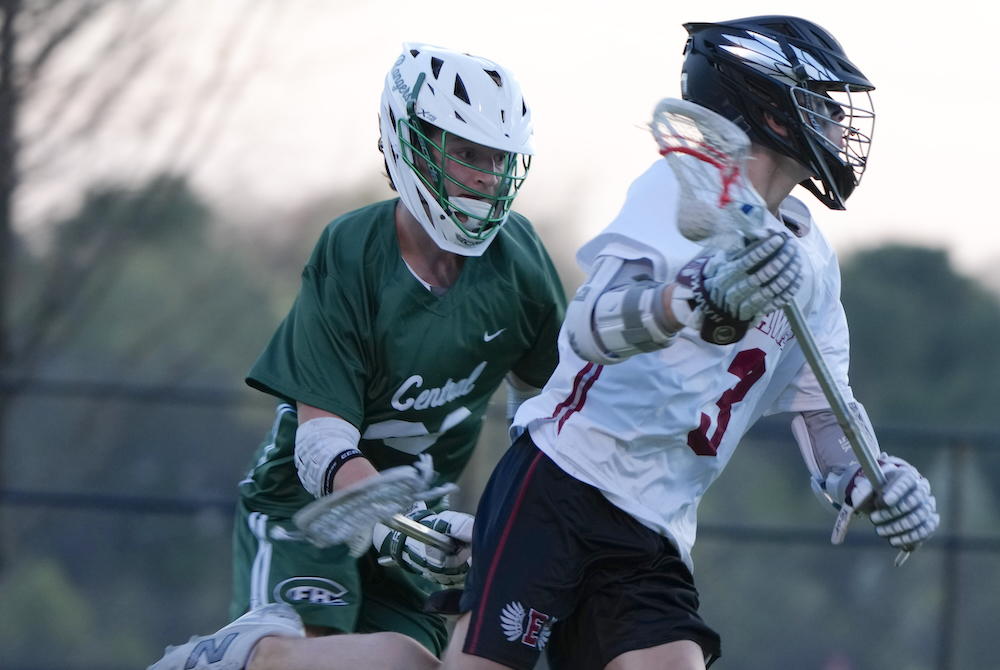 A Grand Rapids Forest Hills Central boys lacrosse player chases a Forest Hills Eastern player with the ball.
