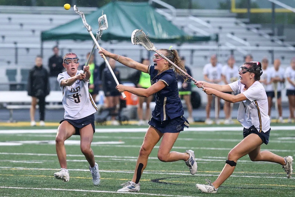 Country Day's Charlotte Cook launches a shot Friday while surrounded by a pair of East Grand Rapids defenders.