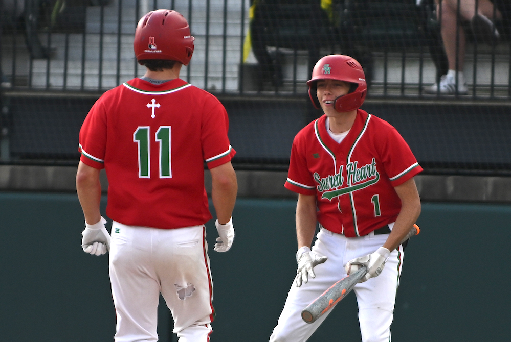 Mount Pleasant Sacred Heart’s Brody Collin (1) welcomes home teammate Brady Davis after Davis crosses the plate during their team’s Division 4 Semifinal win Thursday.