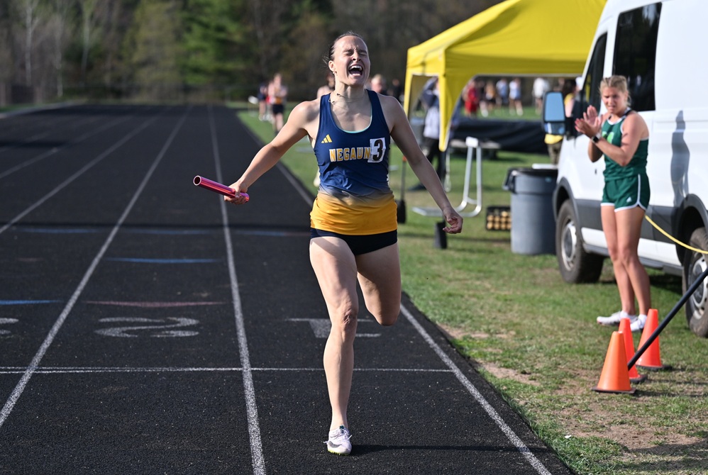 Negaunee's Keira Waterman reacts to breaking the school record in the 1,600 relay (with Sadie Rogers, Riley Conklin, and Brynn Wieciech) as she crosses the finish line during the Mid-Peninsula Conference finals May 18 at Gwinn.