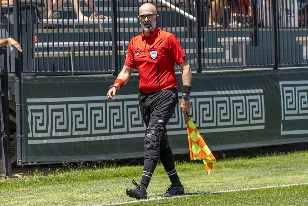 A soccer official monitors the action with flag in hand during the 2026 Girls Soccer Finals.