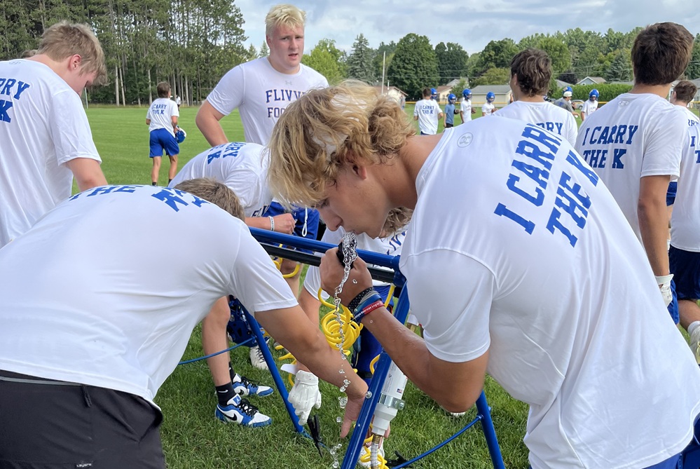 Kingsford football players hydrate during last season's first day of practice.
