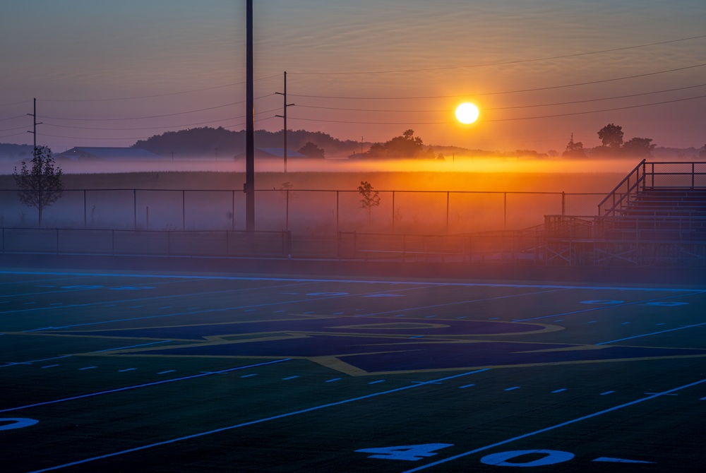 The sun rises on the new stadium turf at Pewamo-Westphalia this summer.