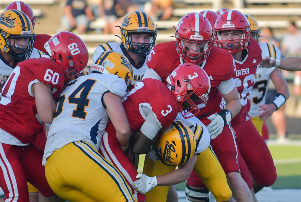 Ithaca defenders wrap up a Mount Pleasant Sacred Heart ball carrier during their 48-6 Week 1 win. 