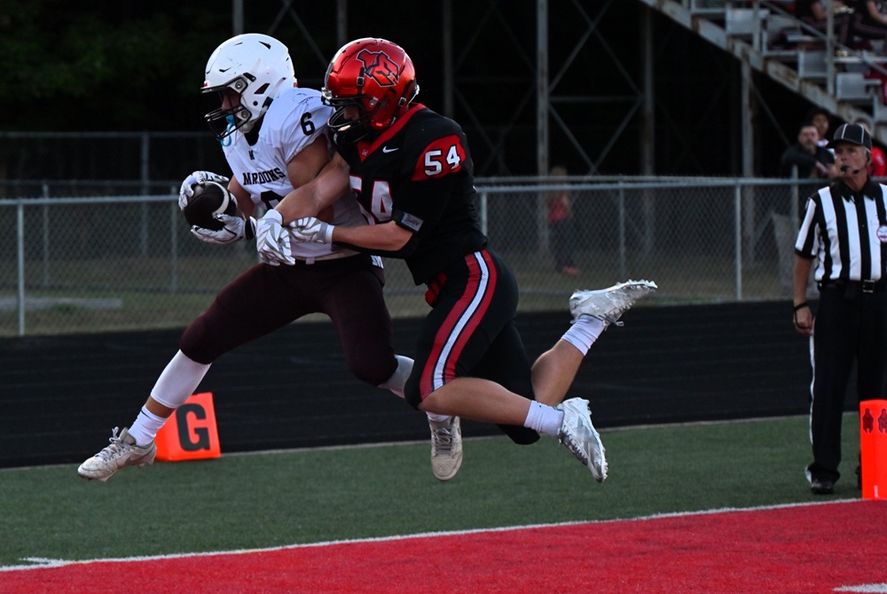Menominee's Jackson Myszak is able to hold onto the ball to score a 2-point conversion while closely covered by Marquette's Josiah Youngren. 
