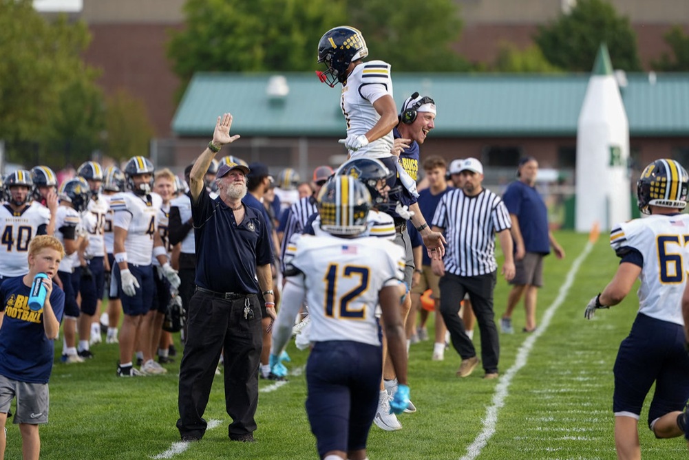 Fourth-year Grand Haven coach Andrew Biedenbender celebrates with wideout Amani Frierson (1) during last week’s victory over Muskegon Reeths-Puffer.