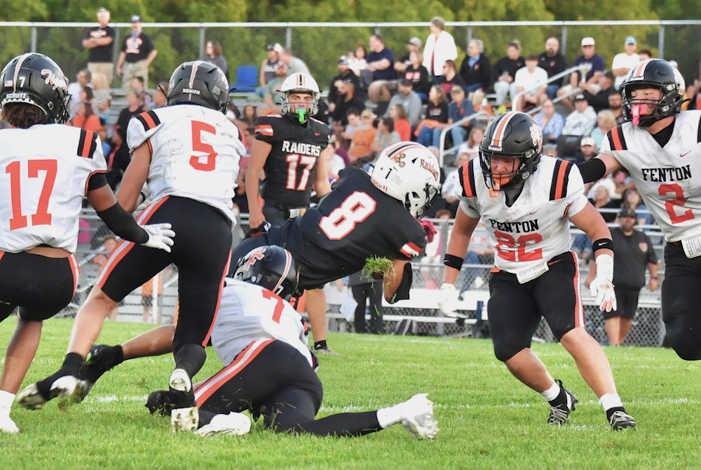 Fenton defenders close in on a tackle during the Tigers’ 26-14 win over Flushing. 