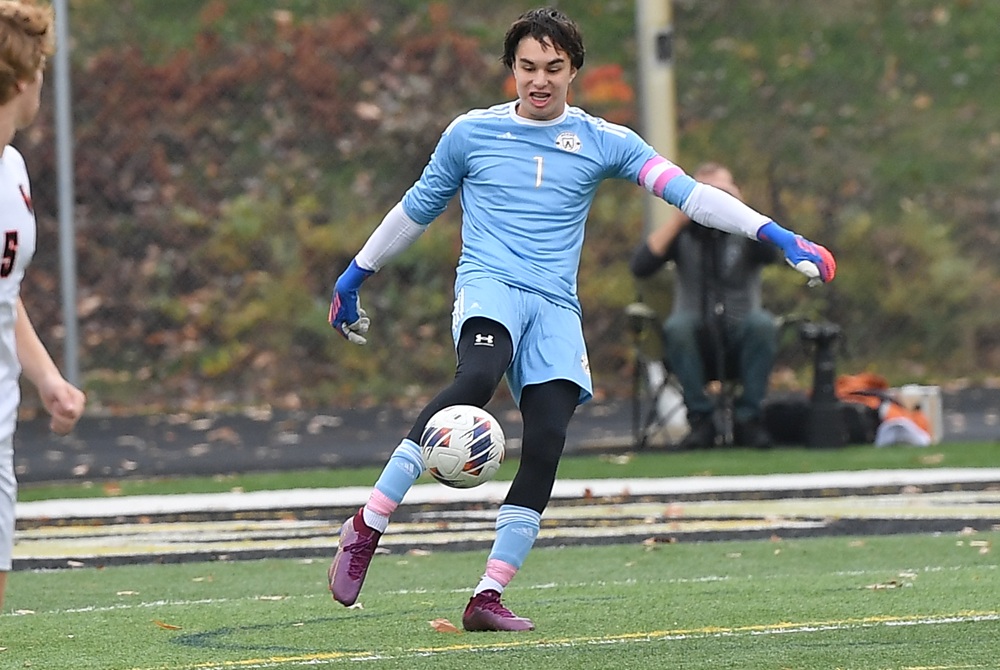 A goalkeeper punts the ball from the front of his box. 