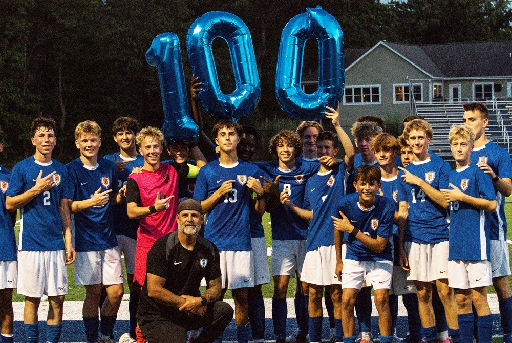 Saugatuck’s Dante Holley (13) stands for a photo with his team after scoring his 100th career goal.
