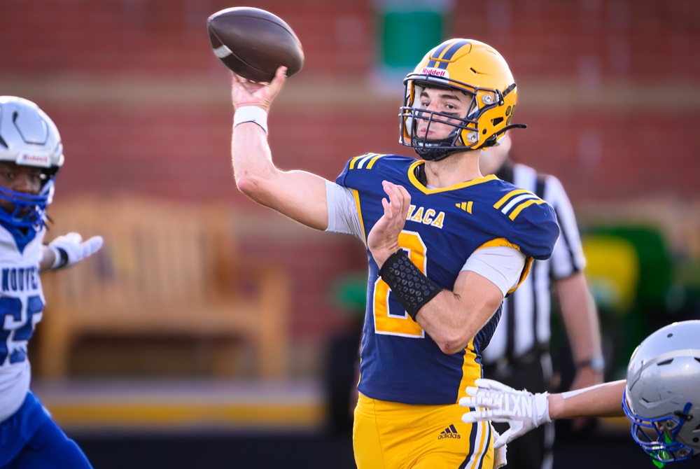 Ithaca senior quarterback Gibson Rondy (2) releases a pass under pressure during the first half of his team’s Week 3 win over Saginaw Nouvel Catholic Central.