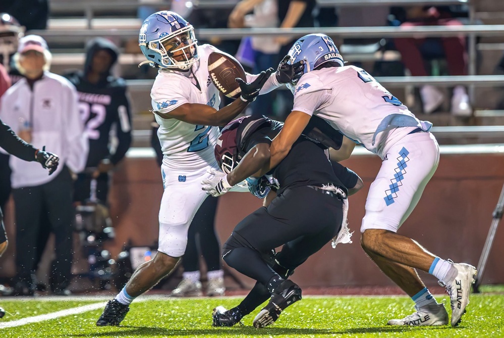  A pair of Muskegon Mona Shores players breaks up a play during their win against Muskegon. 