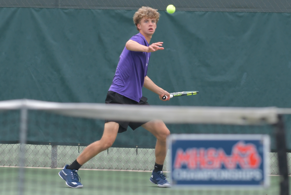 Ann Arbor Pioneer’s Grant Miller prepares to smash a forehand during Friday’s final rounds at Midland Tennis Center. 