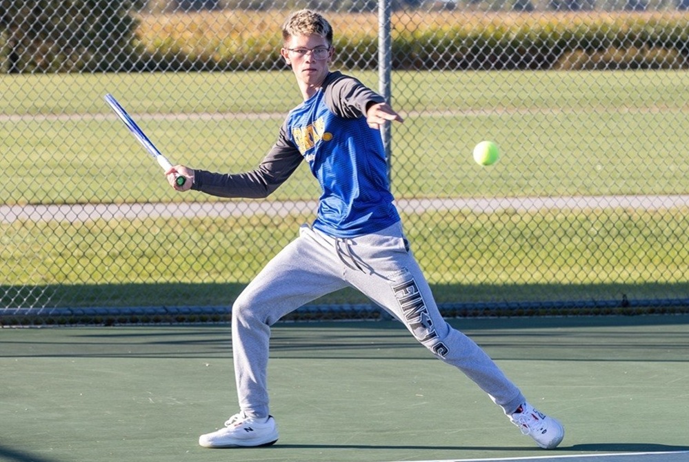 Levi Lengemann winds up for a forehand on the tennis court. 
