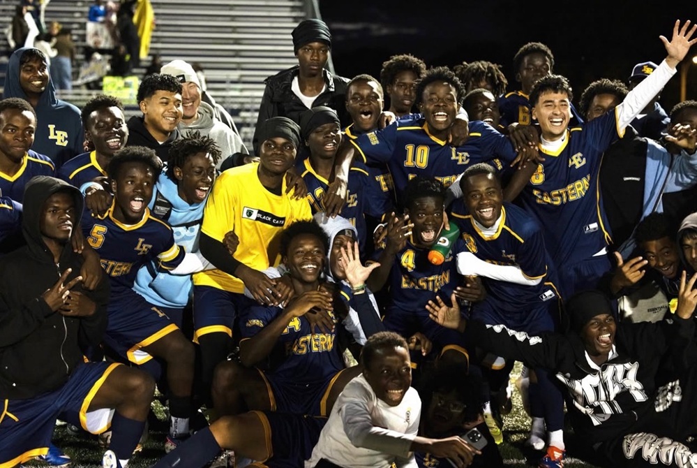 This is a photo of the Lansing Eastern boys soccer team posing together after clinching its league title.