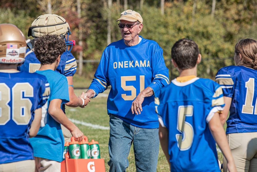 Longtime Onekama coach Jim Taylor shakes hands with current players during the football program’s reunion and recognition night Oct. 10.