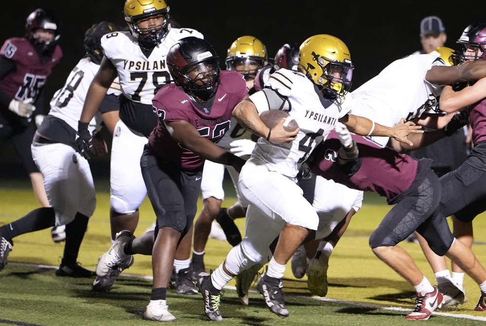 Ada Forest Hills Eastern defenders close in on a Ypsilanti Community ball carrier during the Hawks' 46-22 win on Friday.