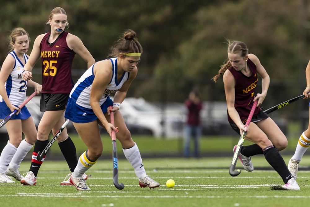 Bloomfield Hills Marian and Farmington Hills Mercy players contend for the ball during a field hockey game this season.