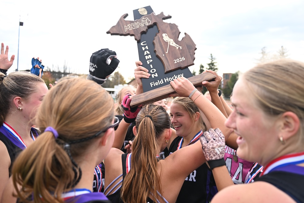 Ann Arbor Pioneer players hoist their championship trophy Saturday at MSU.
